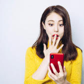 <p>スマホを見て驚く女性</p>