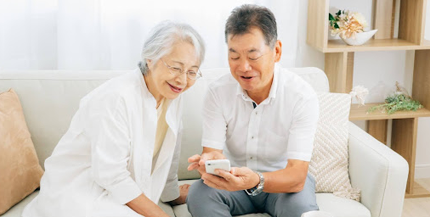 スマホをみながら談笑するシニアの夫婦